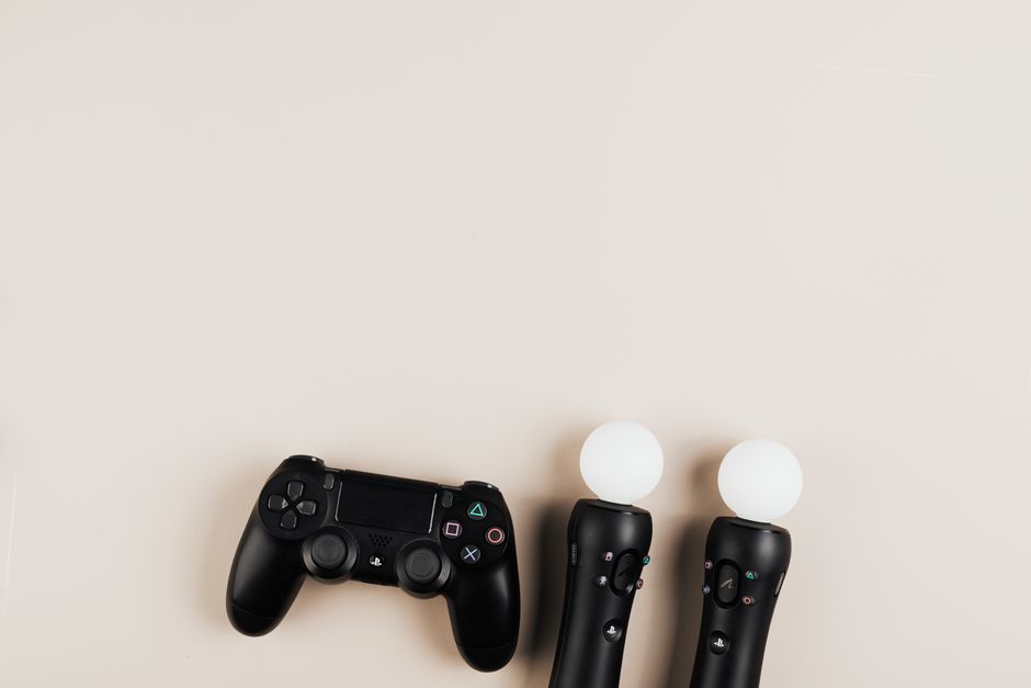 Black gaming controllers arranged on a light background with ample copy space.